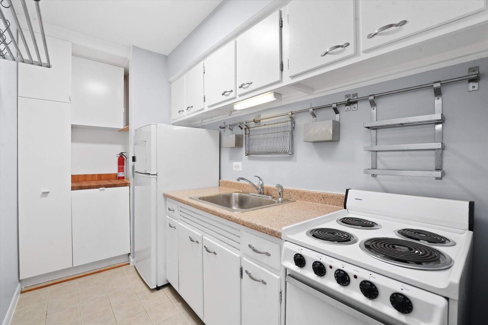 7120 North Sheridan Road, Unit 404 Chicago, IL 60626 - Photo 5 of 21 a kitchen with stainless steel appliances granite countertop a sink stove and white cabinets
