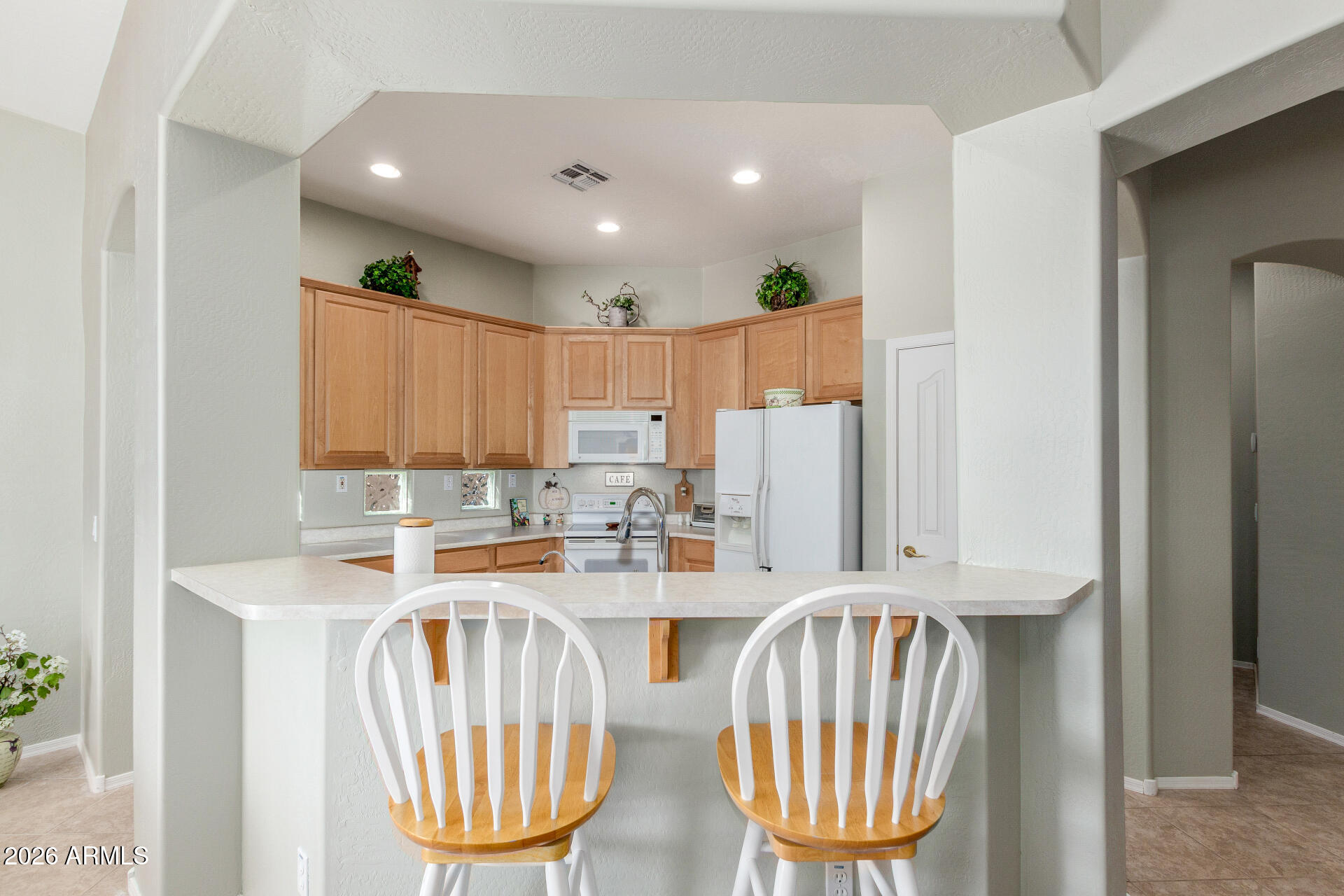 3553 East Washington Avenue Gilbert, AZ 85234 - Photo 10 of 30 a kitchen with stainless steel appliances a dining table chairs and a refrigerator