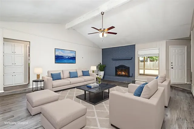 a living room with furniture a fireplace and a flat screen tv