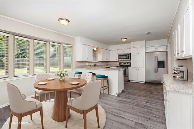 a kitchen with a dining table chairs and refrigerator