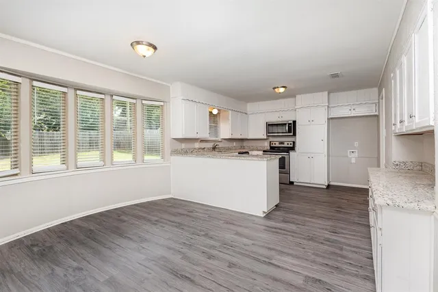 a view of kitchen with granite countertop cabinets and wooden floor