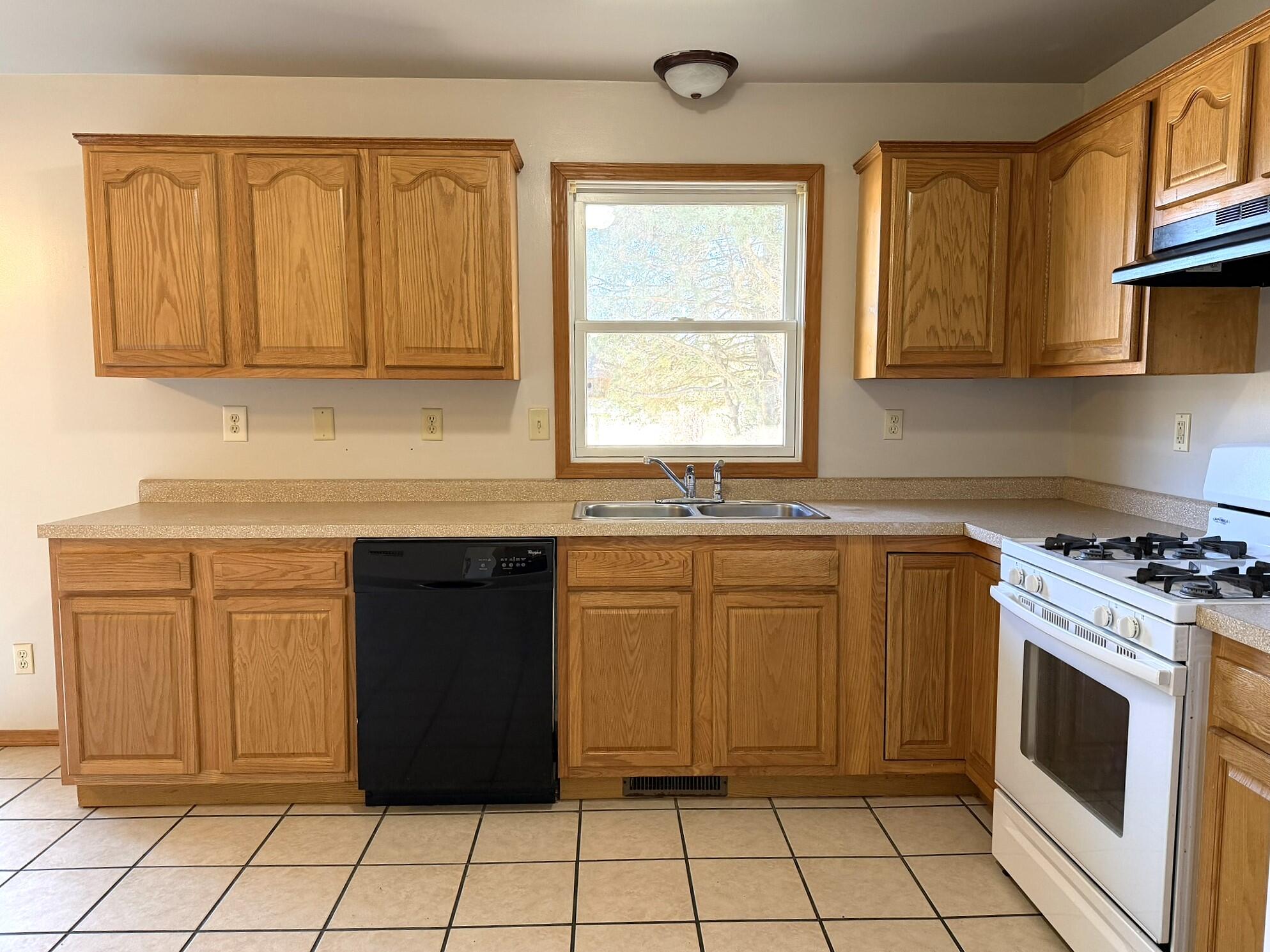 9103 Estates Drive Demotte, IN 46310 - Photo 16 of 35 a kitchen with granite countertop a stove sink and cabinets
