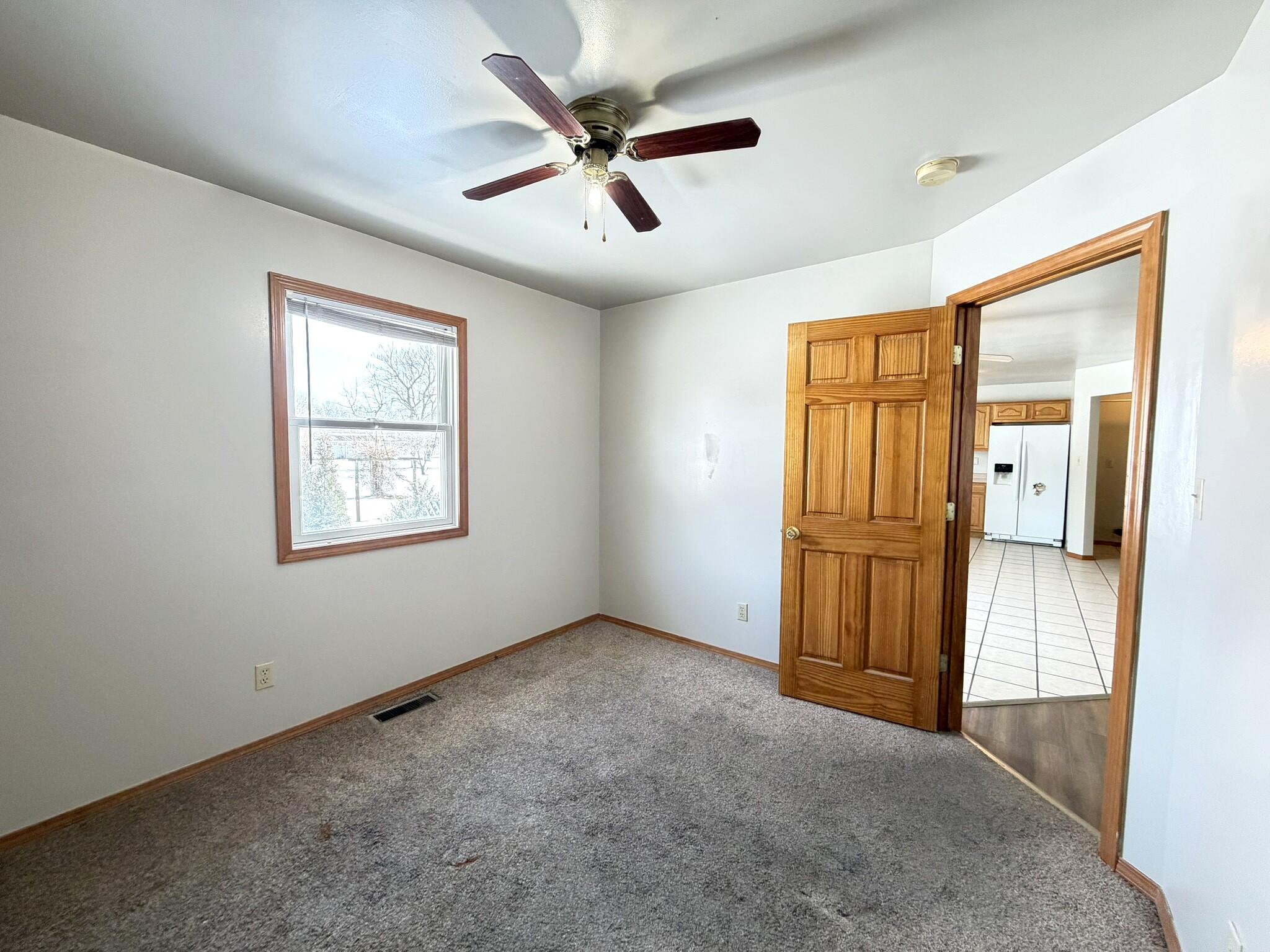 9103 Estates Drive Demotte, IN 46310 - Photo 21 of 35 an empty room with windows and a ceiling fan