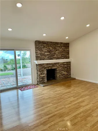 a view of empty room with wooden floor and fireplace