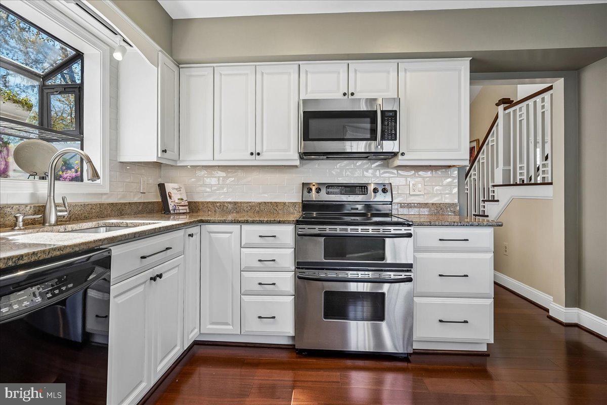 7801 Blue Jasmine Court Springfield, VA 22153 - Photo 12 of 61 a kitchen with white cabinets and stainless steel appliances