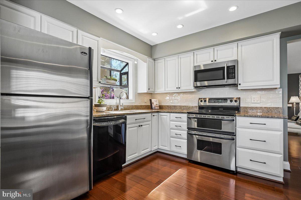 7801 Blue Jasmine Court Springfield, VA 22153 - Photo 14 of 61 a kitchen with granite countertop cabinets stainless steel appliances and a window