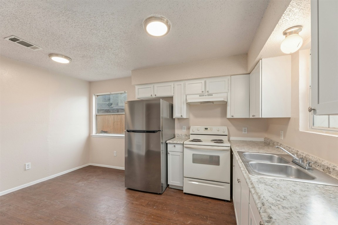 8412 Garcreek Circle Austin, TX 78724 - Photo 12 of 40 The kitchen in Unit A comes with white cabinetry, tasteful laminate countertops, a SS fridge, and an electric range with recirculating range hood.