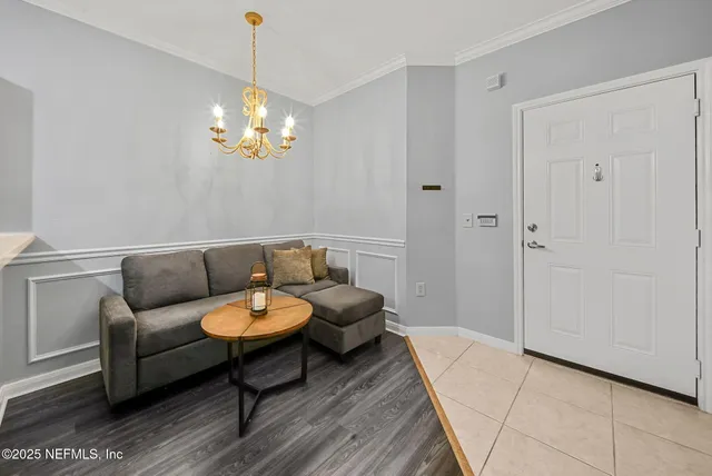 a living room with furniture a chandelier and a rug