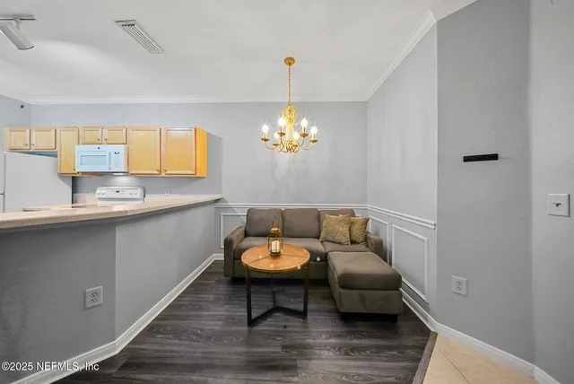 a living room with furniture and a chandelier