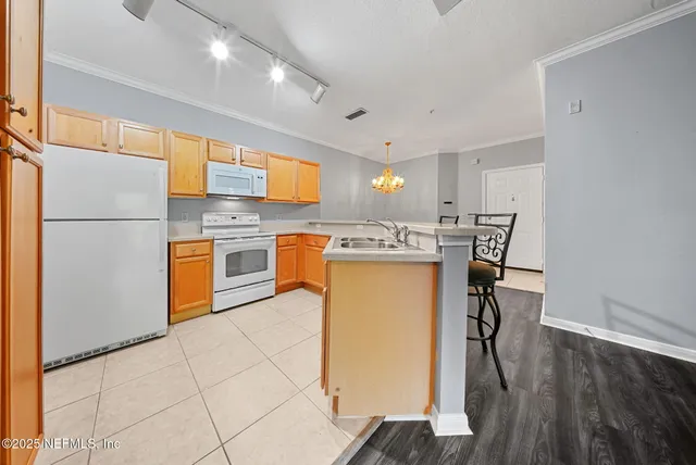 a kitchen with stainless steel appliances a stove a sink refrigerator and a table