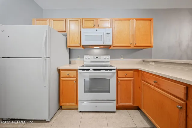 a kitchen with a stove top oven and refrigerator