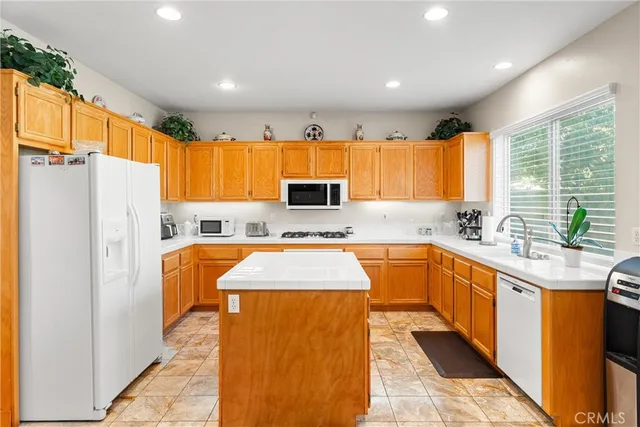 a kitchen with stainless steel appliances granite countertop a refrigerator sink and cabinets