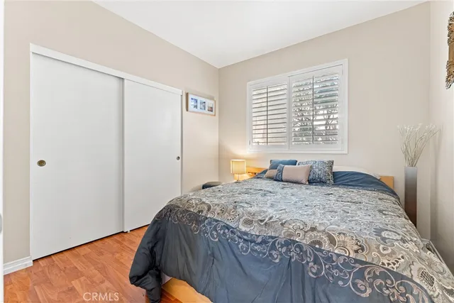 a bedroom with a bed and a window with chair