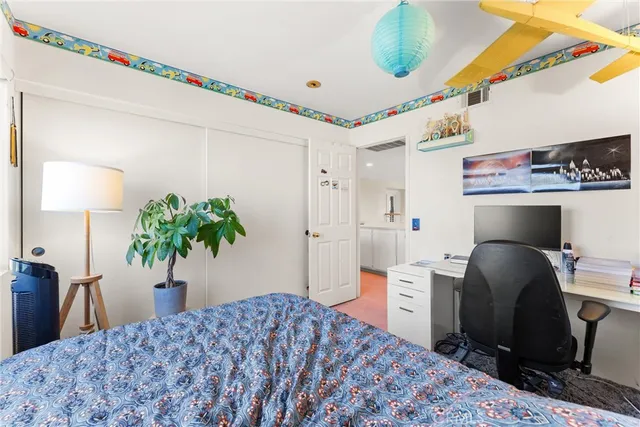 a bedroom with a bed and a potted plant