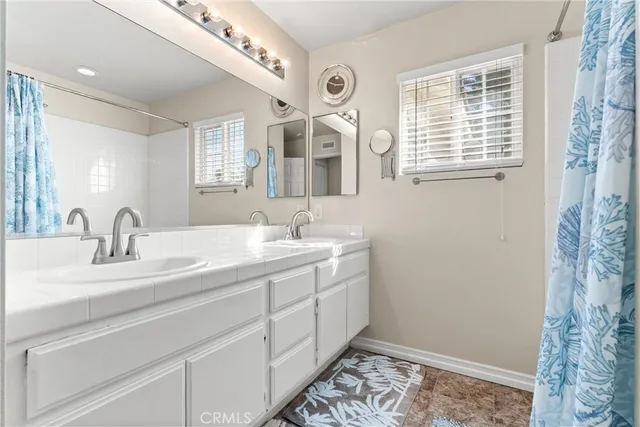 a bathroom with a double vanity sink and a mirror