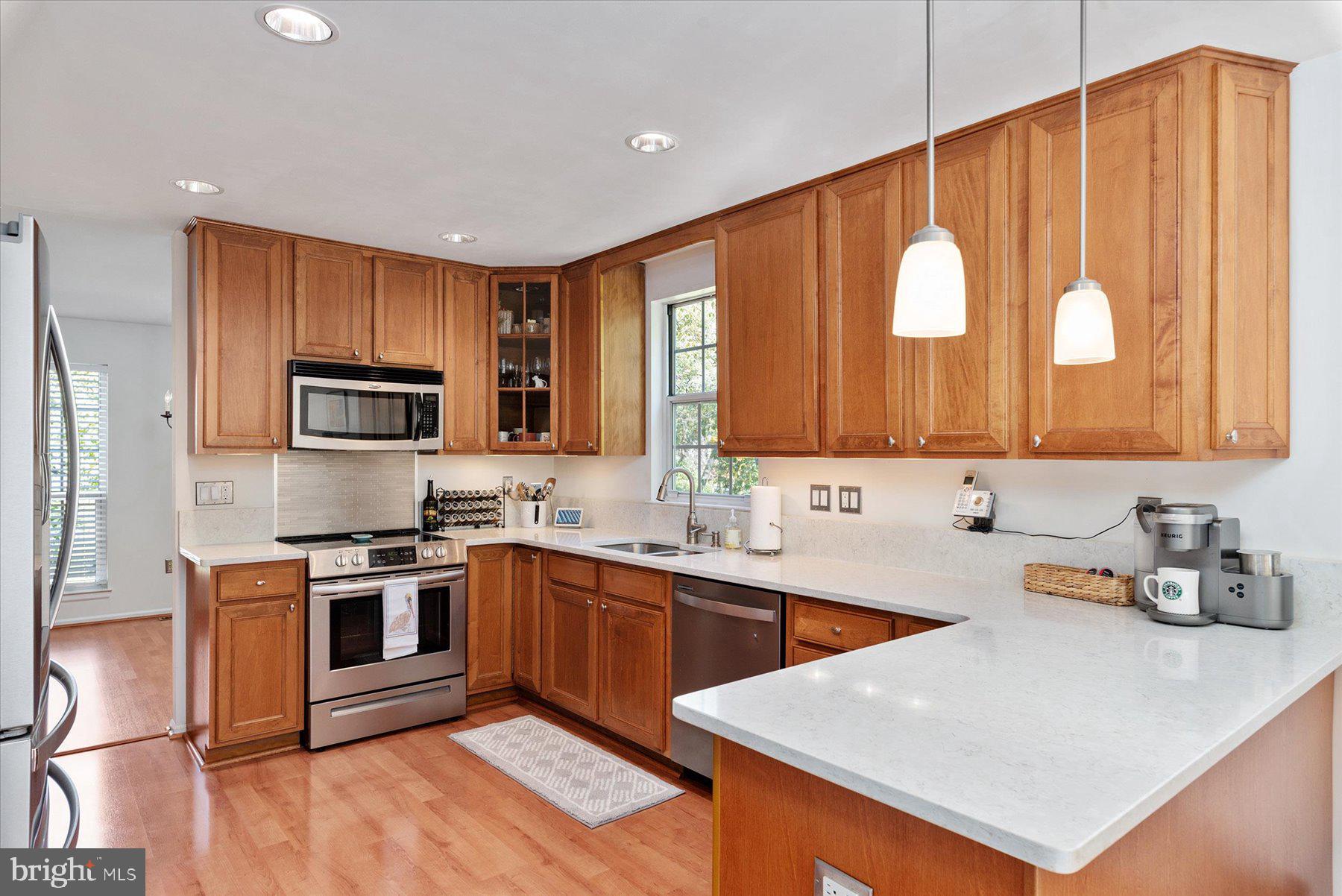 9337 Spring Water Path Jessup, MD 20794 - Photo 10 of 41 a kitchen with stainless steel appliances granite countertop a sink dishwasher stove top oven and refrigerator with wooden floor
