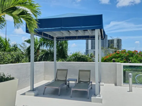 a view of a patio with table and chairs under an umbrella