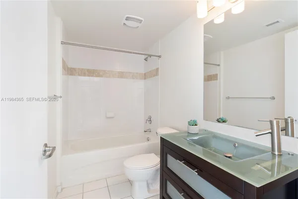 a bathroom with a granite countertop sink a toilet and shower