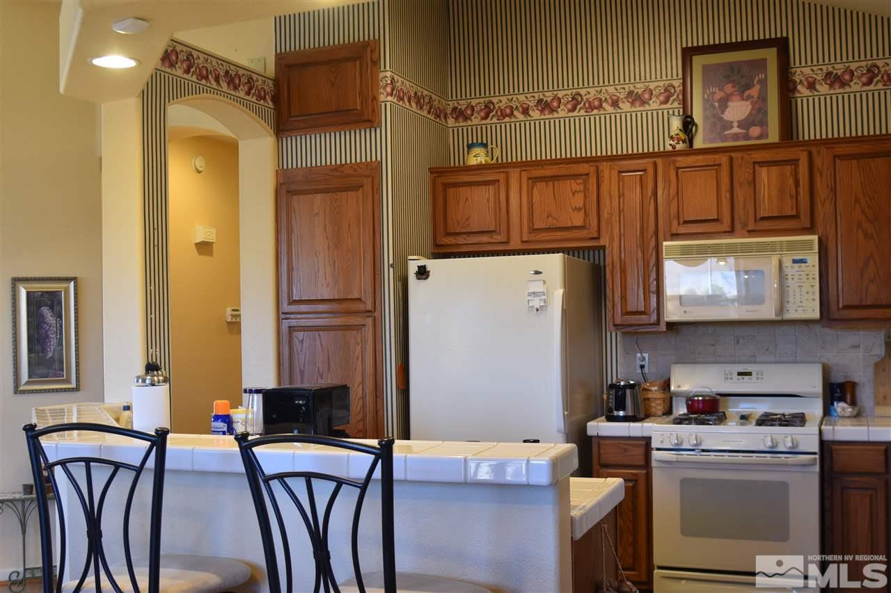 1186 Scenic Park Terrace Reno, NV 89521 - Photo 6 of 18 a kitchen with stainless steel appliances granite countertop a refrigerator and a stove top oven