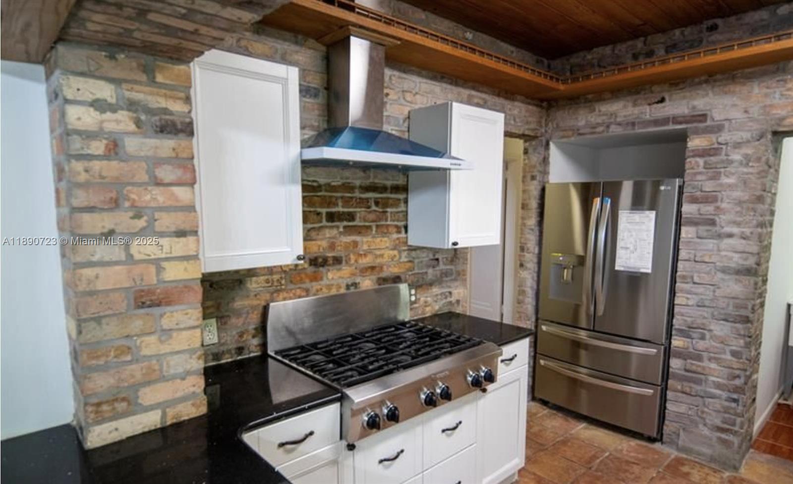3050 Alton Road Miami Beach, FL 33140 - Photo 18 of 41 a kitchen with granite countertop a stove and a refrigerator
