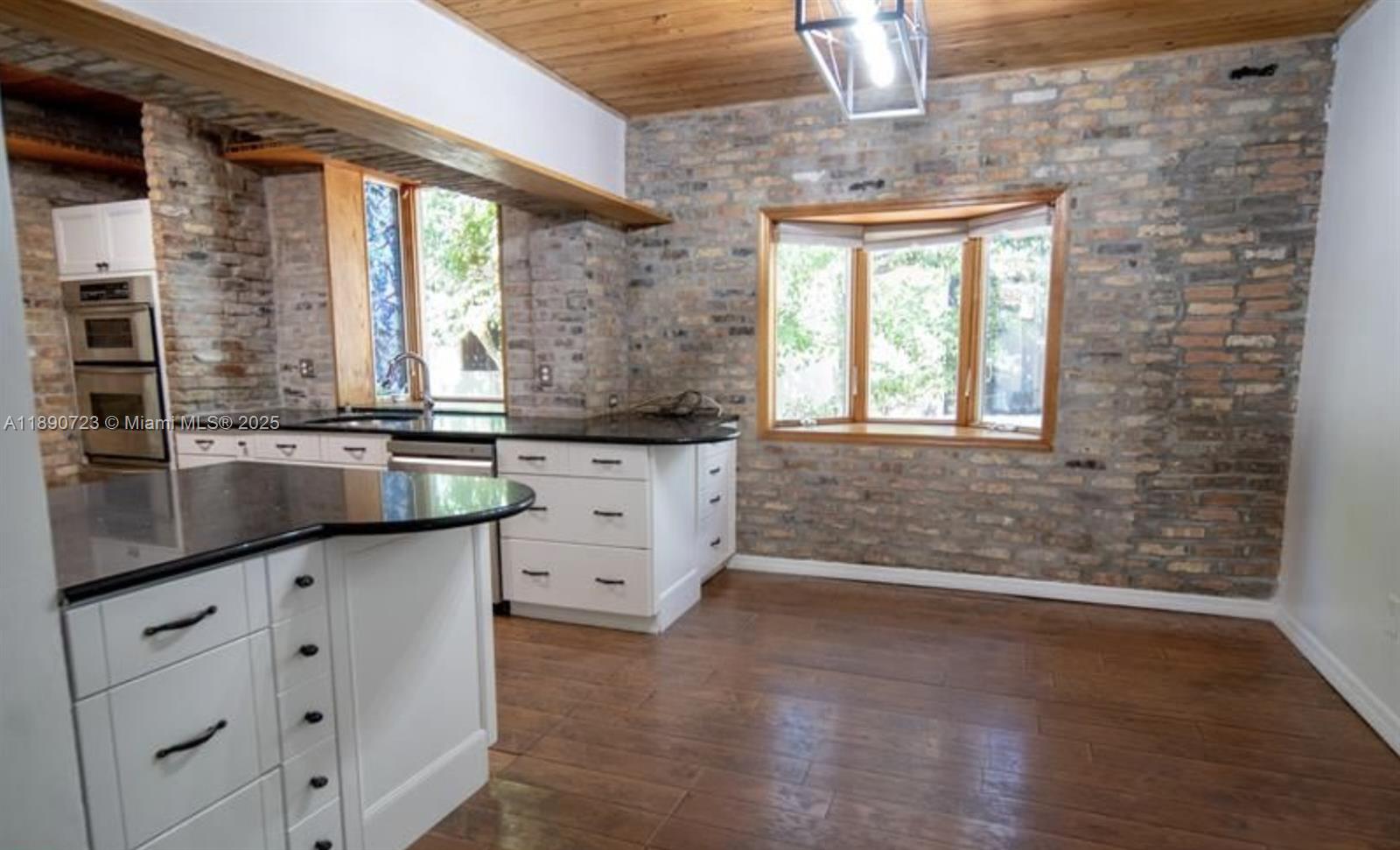 3050 Alton Road Miami Beach, FL 33140 - Photo 21 of 41 a bathroom with a granite countertop sink a large mirror and a bathtub