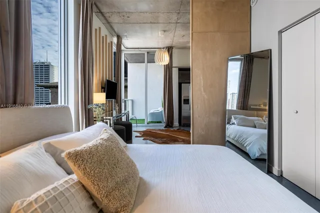 a bedroom with a bed and glass door