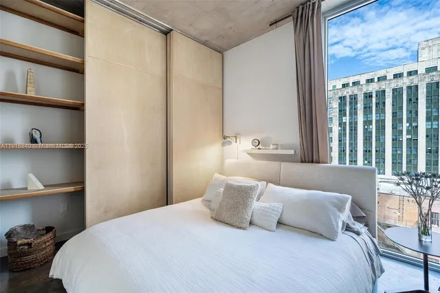 a bedroom with a large bed and a window