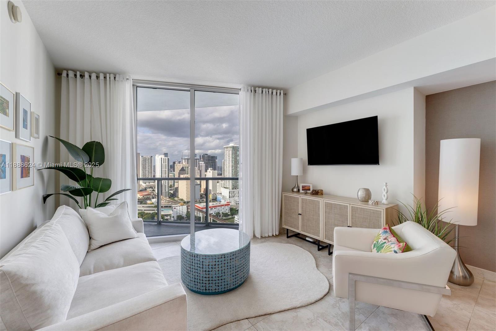 185 Southwest 7th Street, Unit 3605 Miami, FL 33130 - Photo 11 of 24 a living room with furniture a flat screen tv and a large window