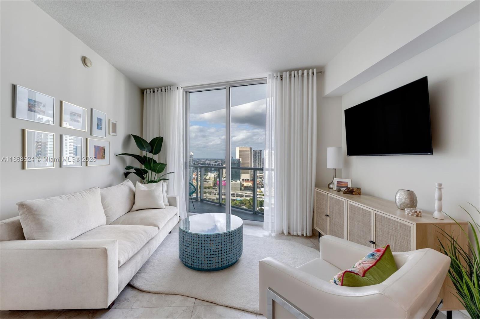 185 Southwest 7th Street, Unit 3605 Miami, FL 33130 - Photo 12 of 24 a living room with furniture and a flat screen tv