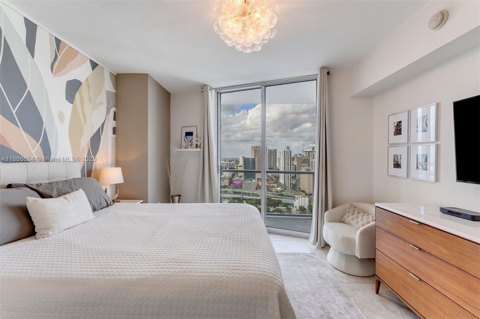 185 Southwest 7th Street, Unit 3605 Miami, FL 33130 - Photo 15 of 24 a bedroom with a large bed and a window