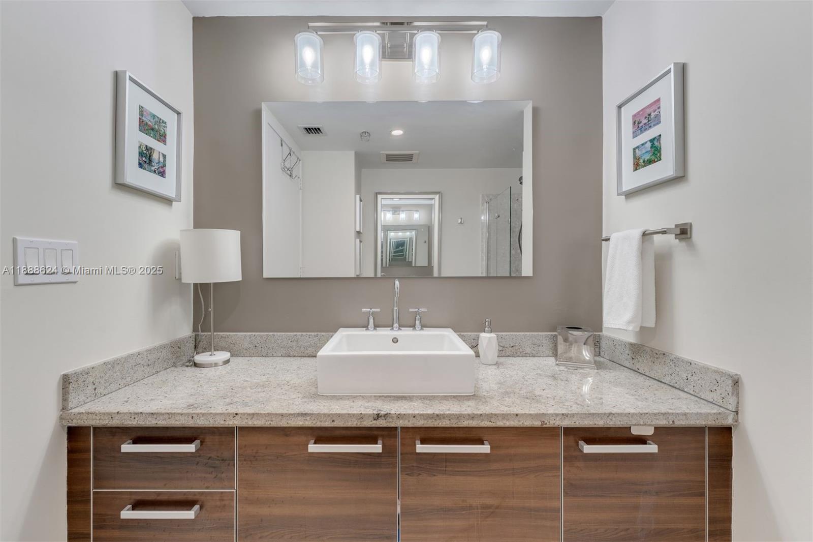 185 Southwest 7th Street, Unit 3605 Miami, FL 33130 - Photo 17 of 24 a bathroom with a granite countertop sink and a mirror