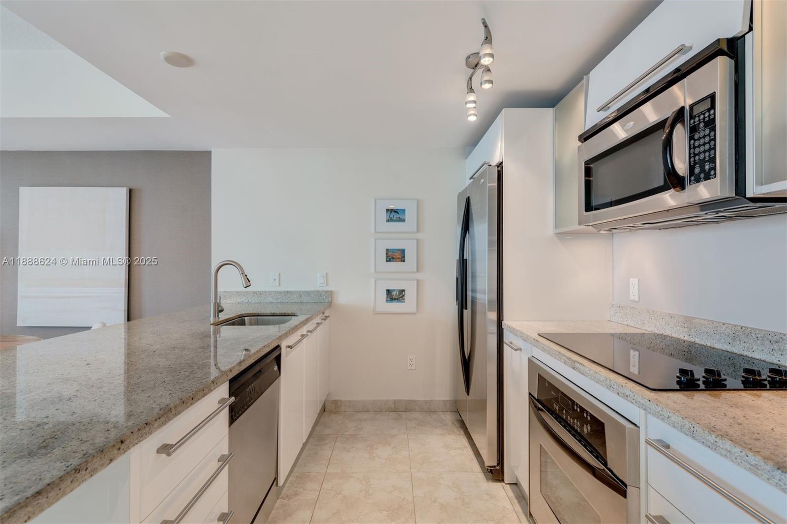 185 Southwest 7th Street, Unit 3605 Miami, FL 33130 - Photo 6 of 24 a kitchen with stainless steel appliances granite countertop a sink and a stove top oven