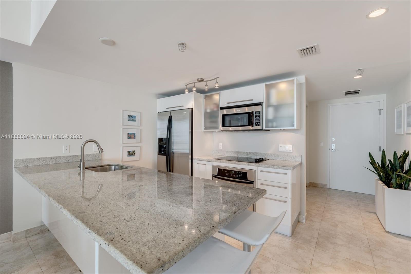 185 Southwest 7th Street, Unit 3605 Miami, FL 33130 - Photo 7 of 24 a kitchen with stainless steel appliances granite countertop a sink a stove and a refrigerator