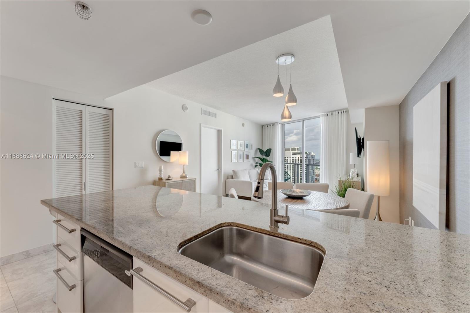 185 Southwest 7th Street, Unit 3605 Miami, FL 33130 - Photo 8 of 24 a kitchen island with a sink and living room view