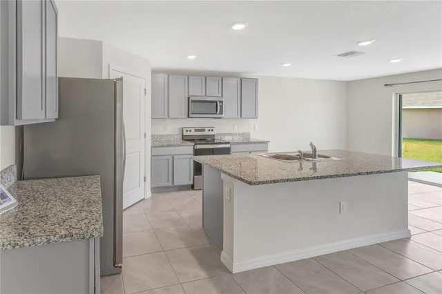 a kitchen with stainless steel appliances granite countertop a sink and a refrigerator