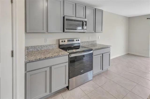 a kitchen with granite countertop white cabinets stainless steel appliances and a sink