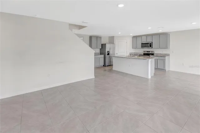 a view of kitchen with kitchen island white cabinets and stainless steel appliances