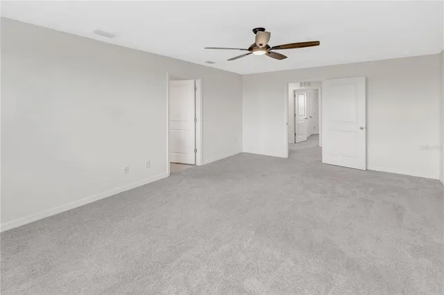 a view of an empty room with a ceiling fan