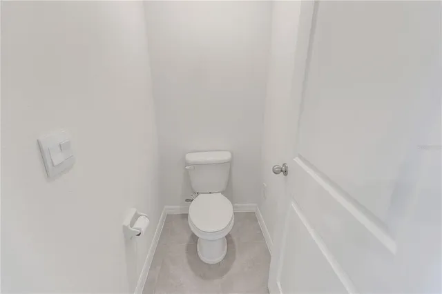 a white toilet sitting next to a white wall