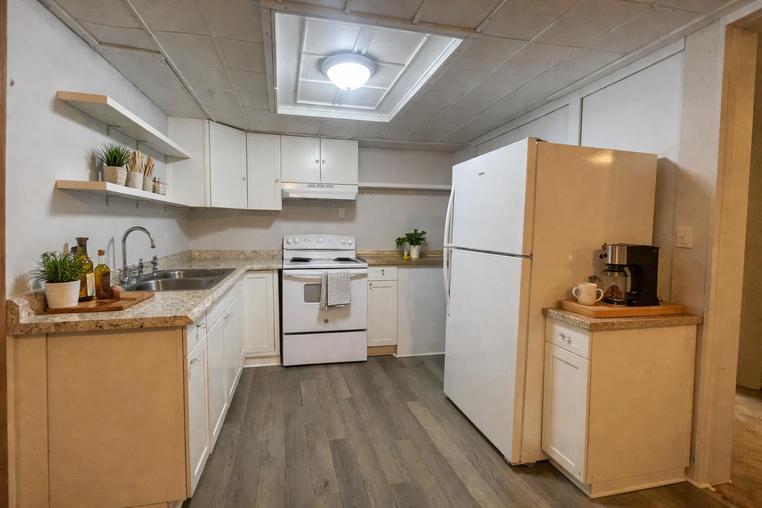 909 A Mapoles Street Crestview, FL 32536 - Photo 2 of 8 a kitchen with a refrigerator a stove top oven a sink and cabinets