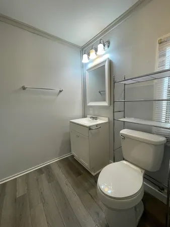 a white toilet sitting next to a bathroom sink and a mirror