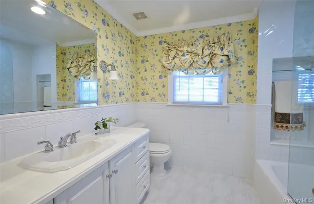 a bathroom with a sink a toilet and a mirror