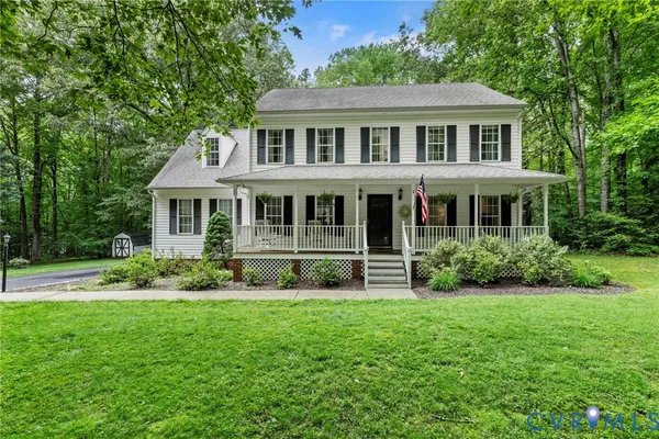 a front view of a house with a yard and potted plants