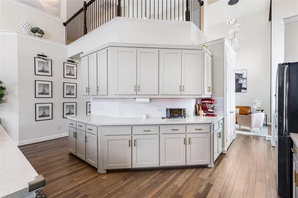 a kitchen with stainless steel appliances white cabinets and wooden floors