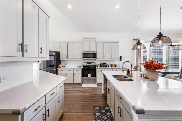 a kitchen with a sink a stove and cabinets