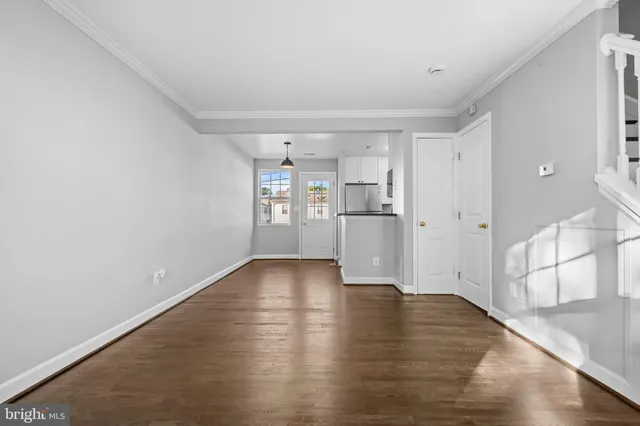a view of a kitchen with wooden floor and a refrigerator