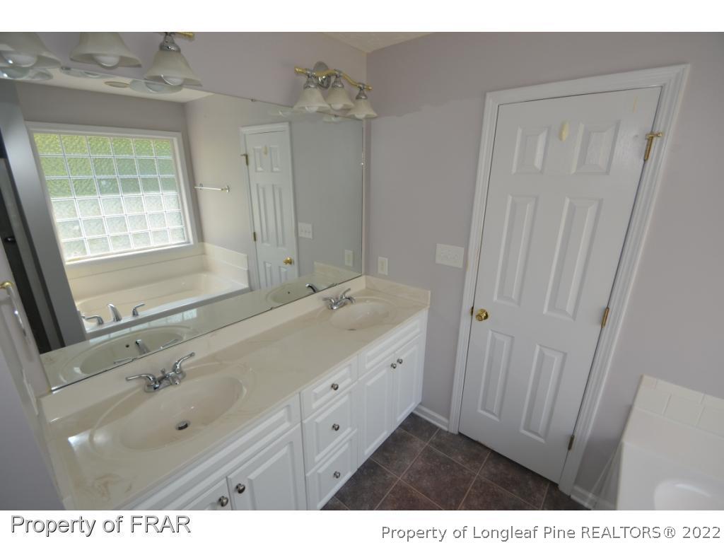 62 Robeson Court Spring Lake, NC 28390 - Photo 7 of 19 a bathroom with a double vanity sink a mirror and a bathtub