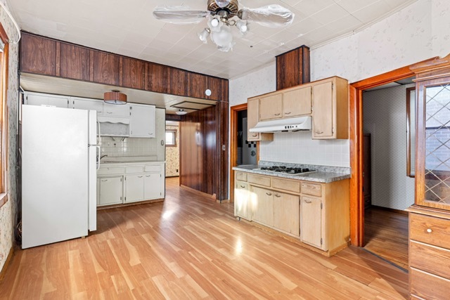 3047 South Broad Street Chicago, IL 60608 - Photo 6 of 15 a kitchen with granite countertop a refrigerator and a stove top oven