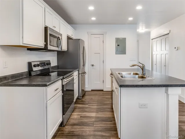 a kitchen with stainless steel appliances granite countertop a sink stove and refrigerator