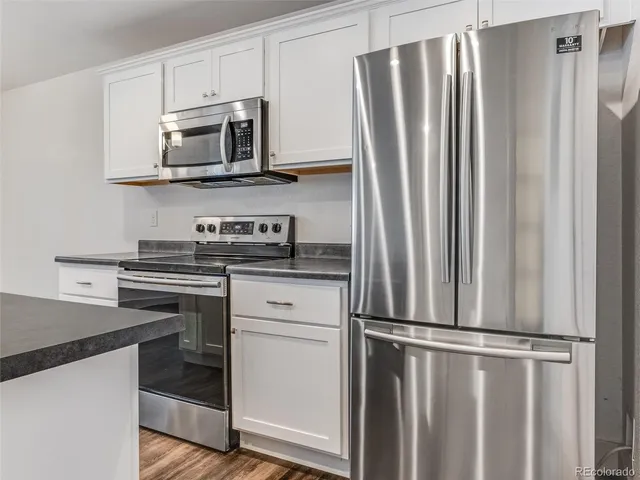 a kitchen with stainless steel appliances a refrigerator stove and microwave